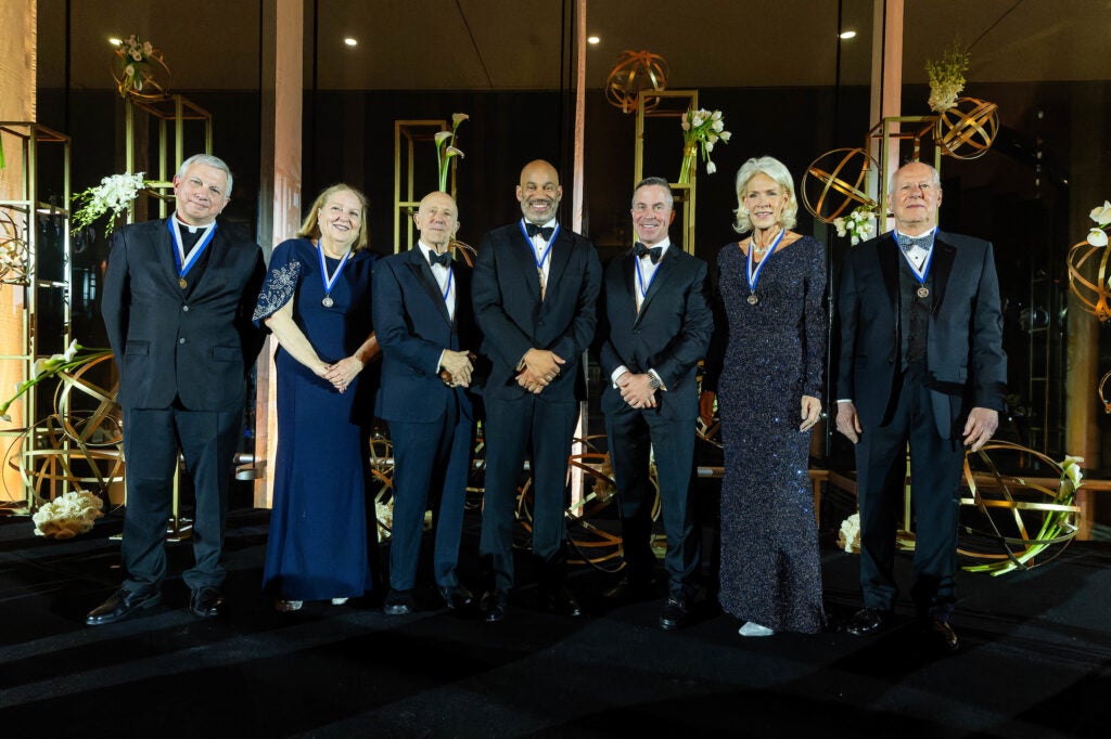 people in formalwear stand on a stage